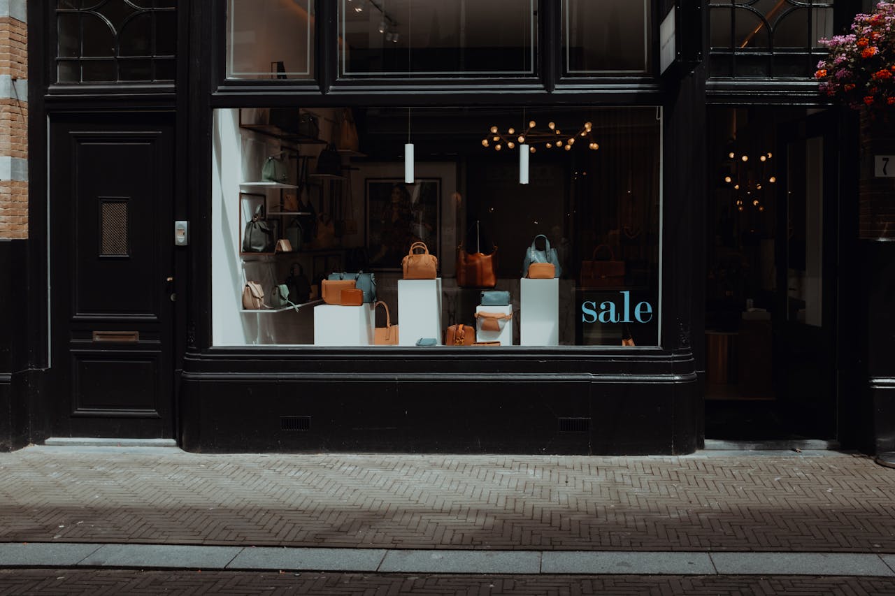 Stylish boutique storefront featuring elegant handbags on sale, inviting window display.
